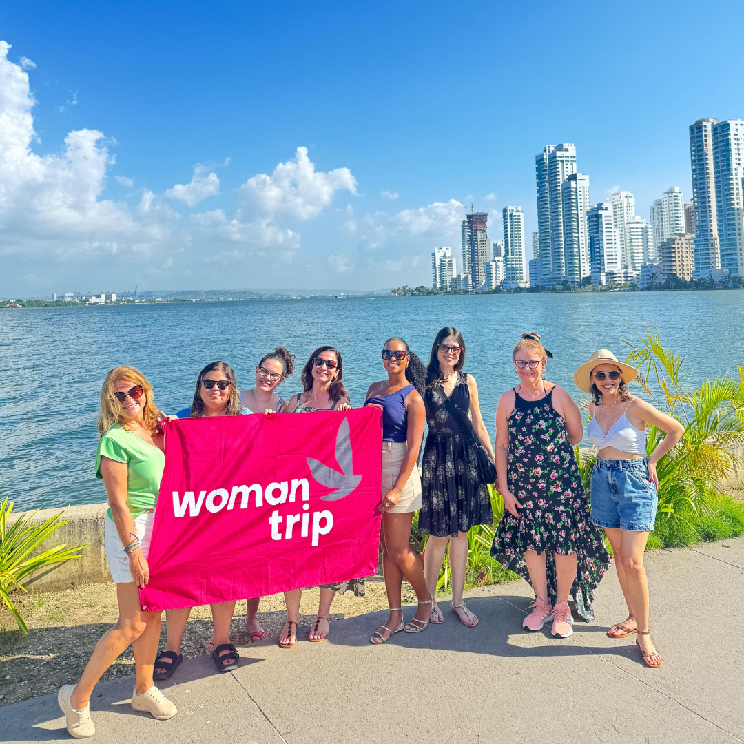 Grupo de mulheres em passeio pela praia de Cartagena com o skyline da cidade ao fundo